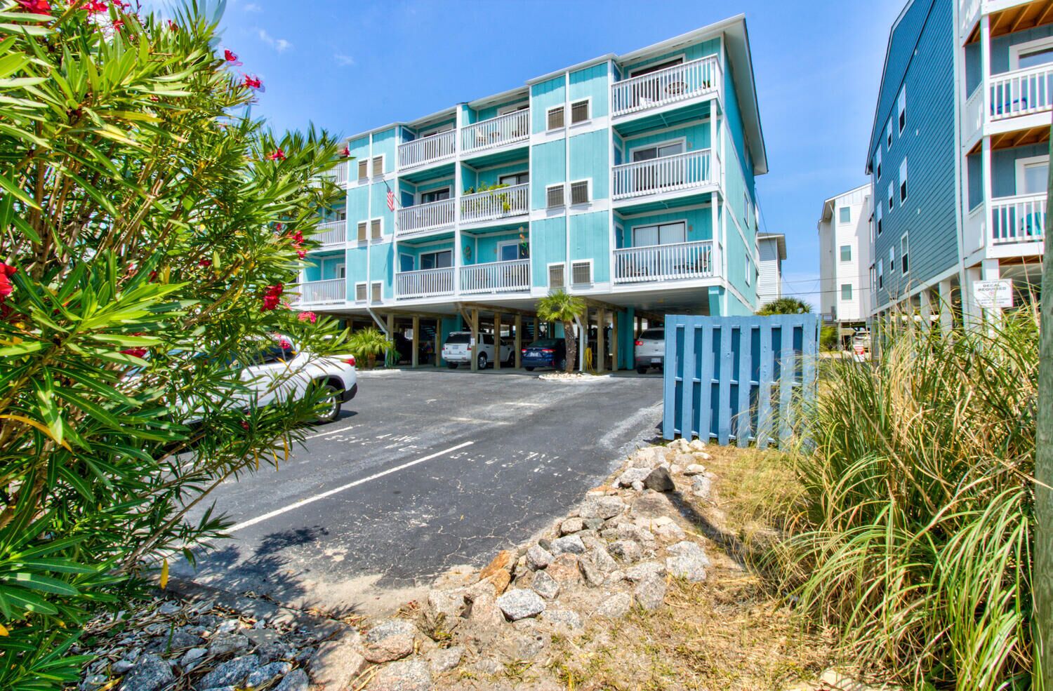 Ein mehrstöckiges Hotel mit blauer Fassade, Außenparkplatz und einem verschlossenen Eingang.