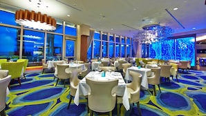 A restaurant with round tables and chairs, large windows, and a blue carpet. - $189 30 Steps from Beach l 3min Rest/Shops (Clearwater Beach)