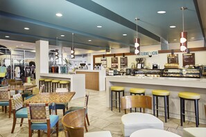 Café offers a variety of seating options and a display case with pastries.