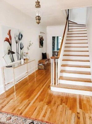 Stairs lead up to a spacious interior with a polished floor and a decorative wall piece.