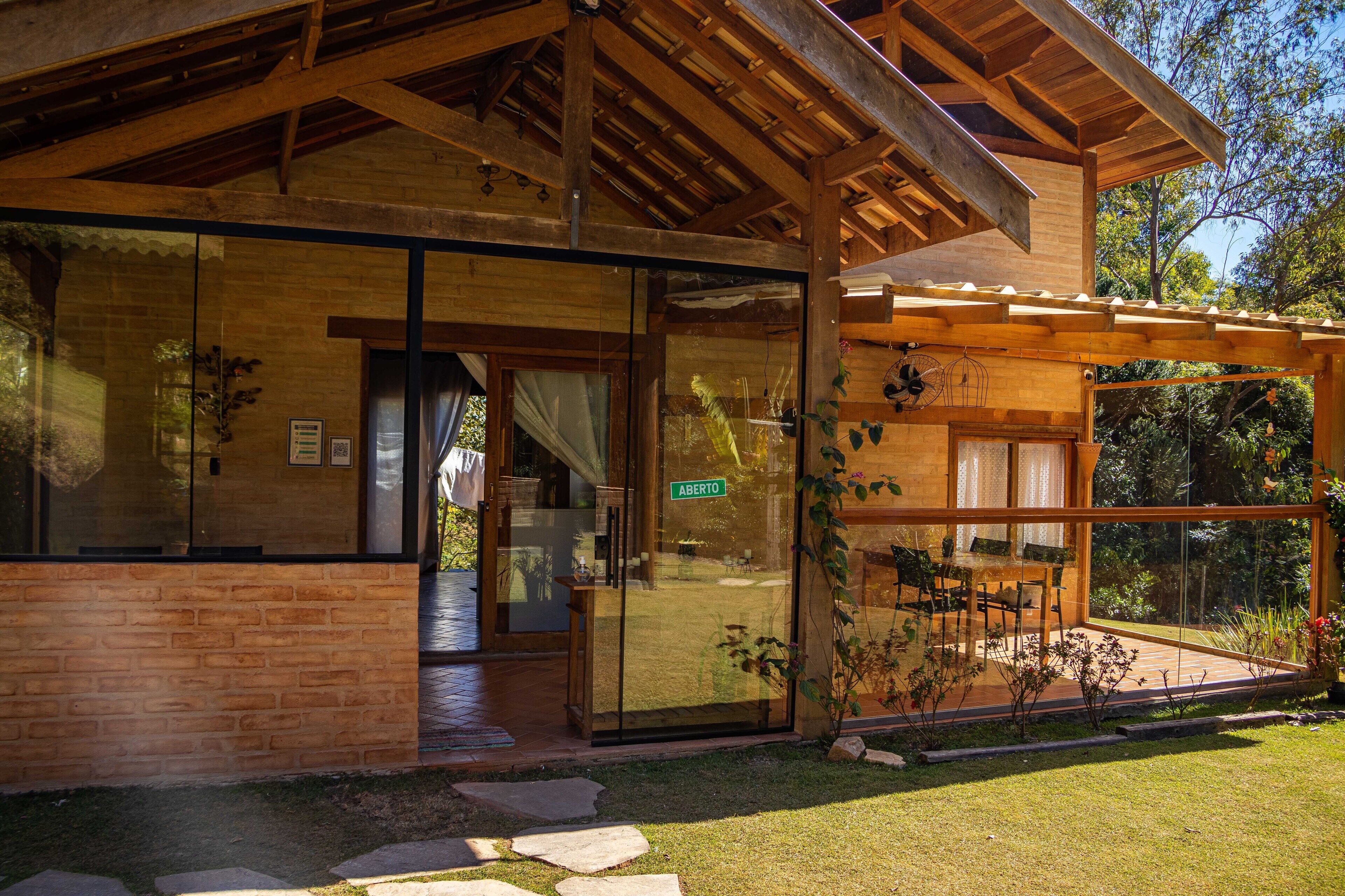 A modern building with large glass windows, a wooden pergola, and a brick facade.
