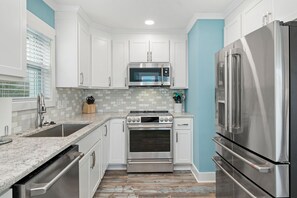 Enjoy cooking in this well-equipped kitchen with a refrigerator, oven, and microwave.