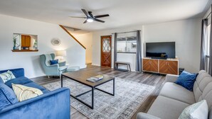 A modern living room with a sofa, armchair, coffee table, and a television. - Private A-Frame w/Kayaks on Canal newly renovated (Granbury)
