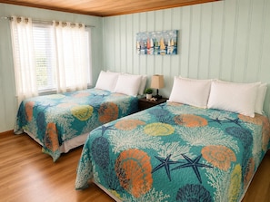 A bedroom with two beds, a painting on the wall, and a window with curtains.