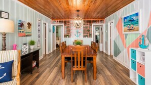 A dining area with a wooden table and chairs, a chandelier, and nautical-themed decor. - Saltwater Pool, Large Dog Friendly, Steps to the beach!  (North Myrtle Beach)