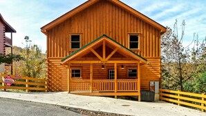 A wooden cabin with a front porch, a number '3230' on the front, and a sign indicating 'Cabins USA'. - Pool! Hot Tub - Movie Room - Game Room - Dollywood (Sevierville)