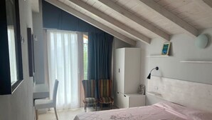 Ein Schlafzimmer mit einem Bett, einem Sessel, einem Schreibtisch und einem Kleiderschrank.