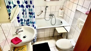 Kombinert dusj/badekar, håndklær og toalettpapir