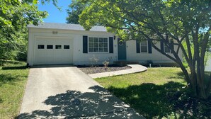 A single-story house with a garage, a front porch, and a tree in the yard. - Remodeled Home - Near Faurot Field! (Columbia)
