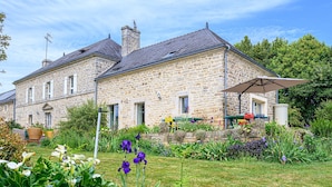 A stone house with a garden and outdoor seating area. - Ker Case A Nou - Longère à la campagne (Monterblanc)