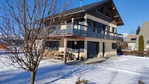 A modern two-story house with a balcony, a garage, and a snow-covered yard. - Le Château D'Ancelle (Ancelle)