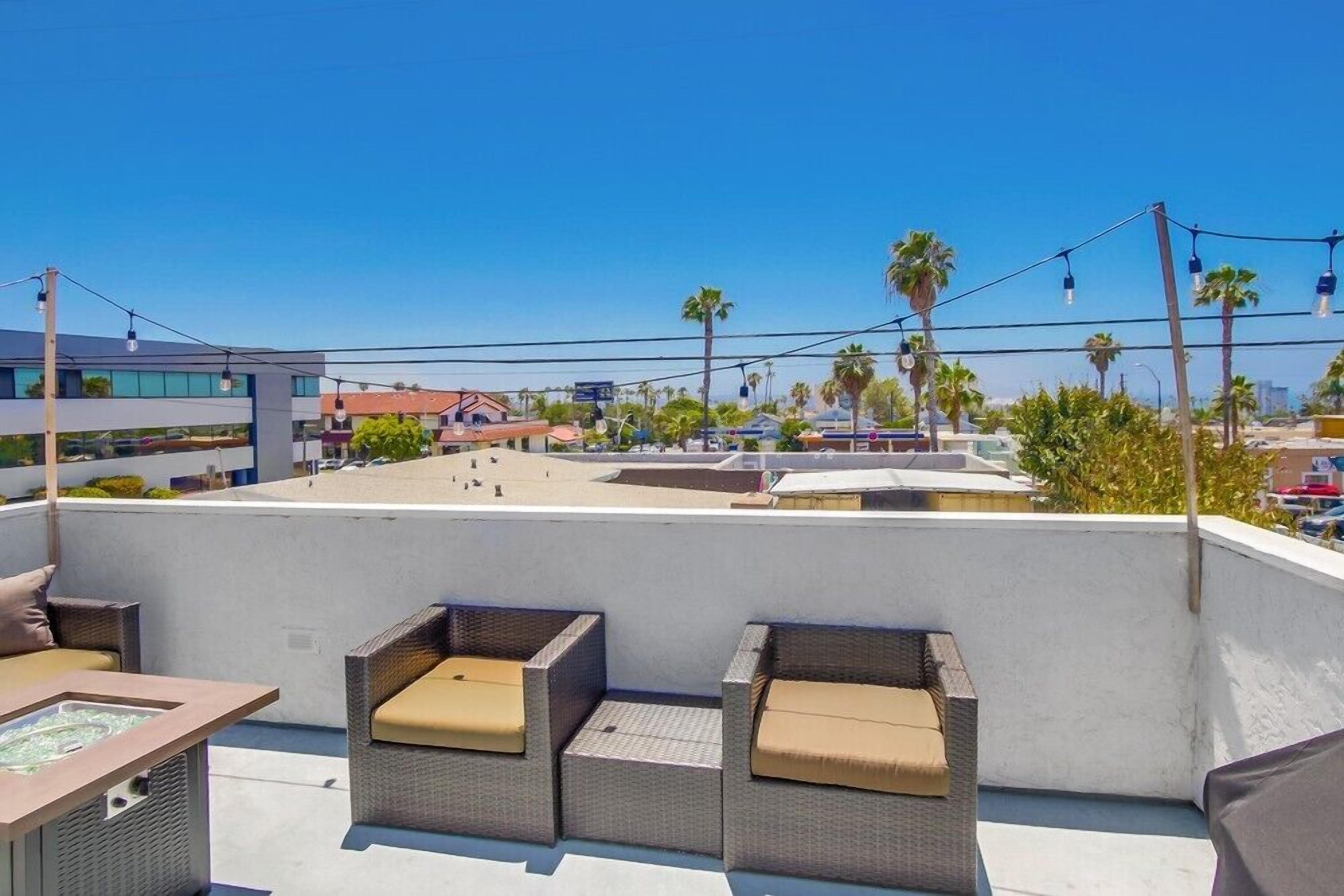 Une terrasse sur le toit, aménagée avec des meubles en osier et dotée d’un jacuzzi.