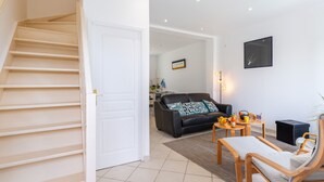 Una escalera conduce a una sala de estar con un sofá, una mesa de centro y sillas.