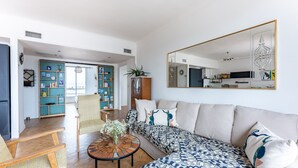 Un salon moderne comprenant un canapé, des fauteuils, une table basse et une bibliothèque.