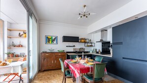 Une cuisine moderne avec un coin repas, comprenant une table en bois, des chaises et une nappe rouge.