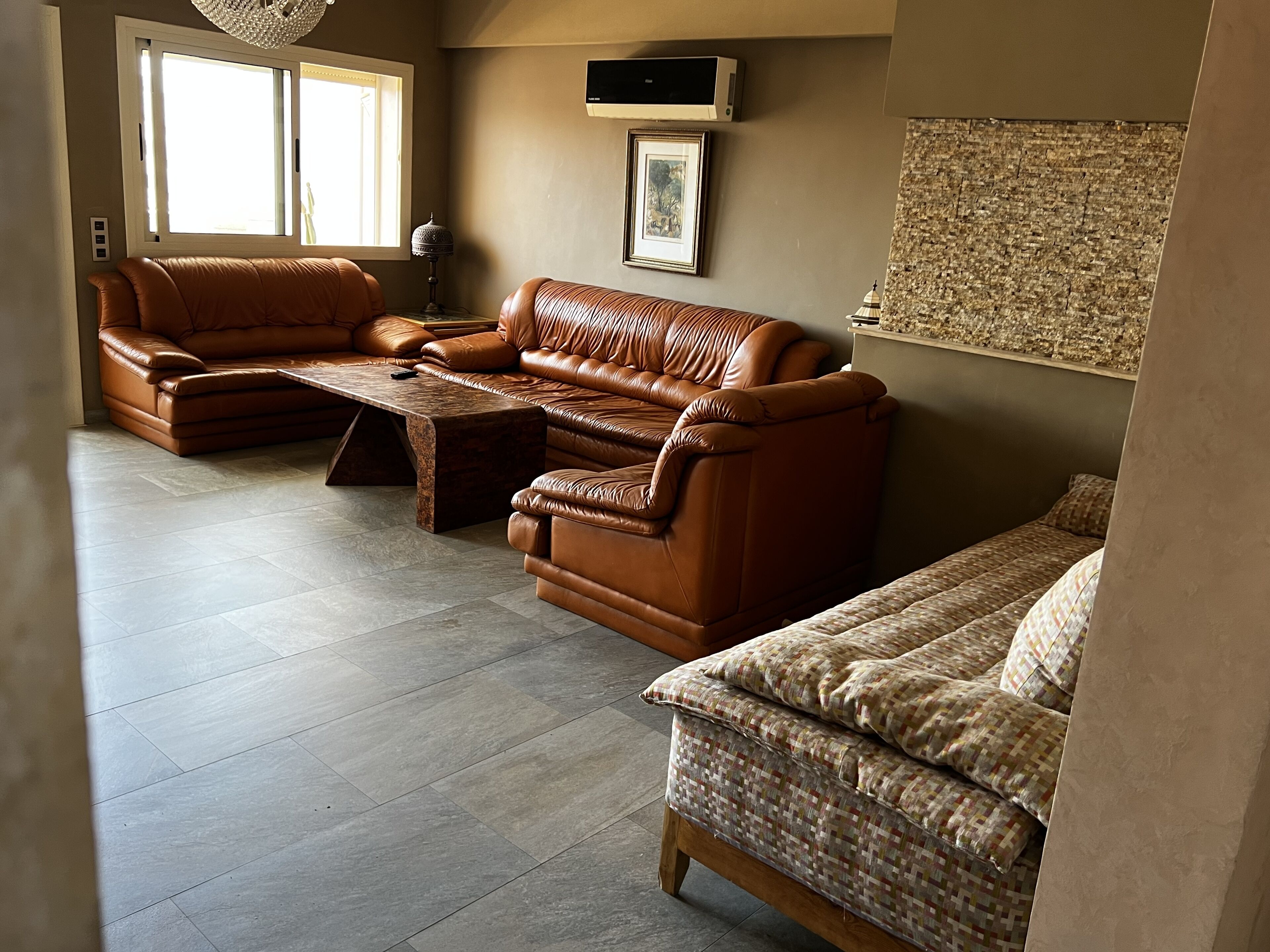 A living room with leather sofas, a coffee table, and a patterned rug.