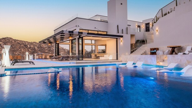 A modern pool area with a clear view of the pool, lounge chairs, and a staircase leading to a second floor. - Luxury Villa w/ Tennis, Pickleball, Pool, Hot Tub & Fitness Room, Views (Cabo San Lucas)