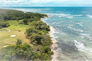 A coastal landscape with a golf course and beach.