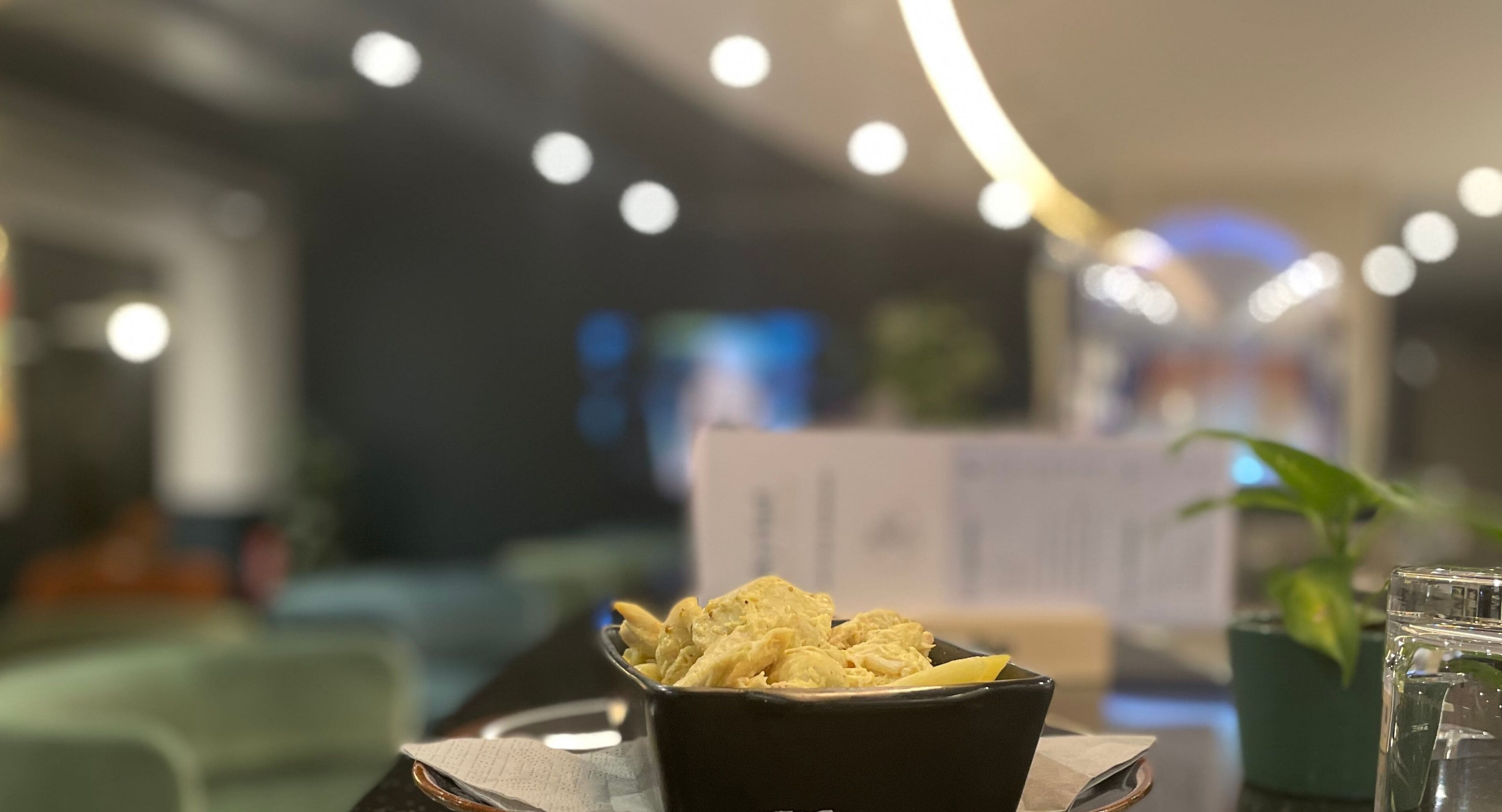 A bowl of chips on a table in a restaurant setting.