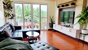 Ein modernes Wohnzimmer mit einem Ledersofa, einem runden Couchtisch und einem flachbildfernseher an der Wand.