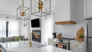 Une cuisine moderne dotée d’un îlot central, d’un four encastré, d’une cuisinière et d’un réfrigérateur.