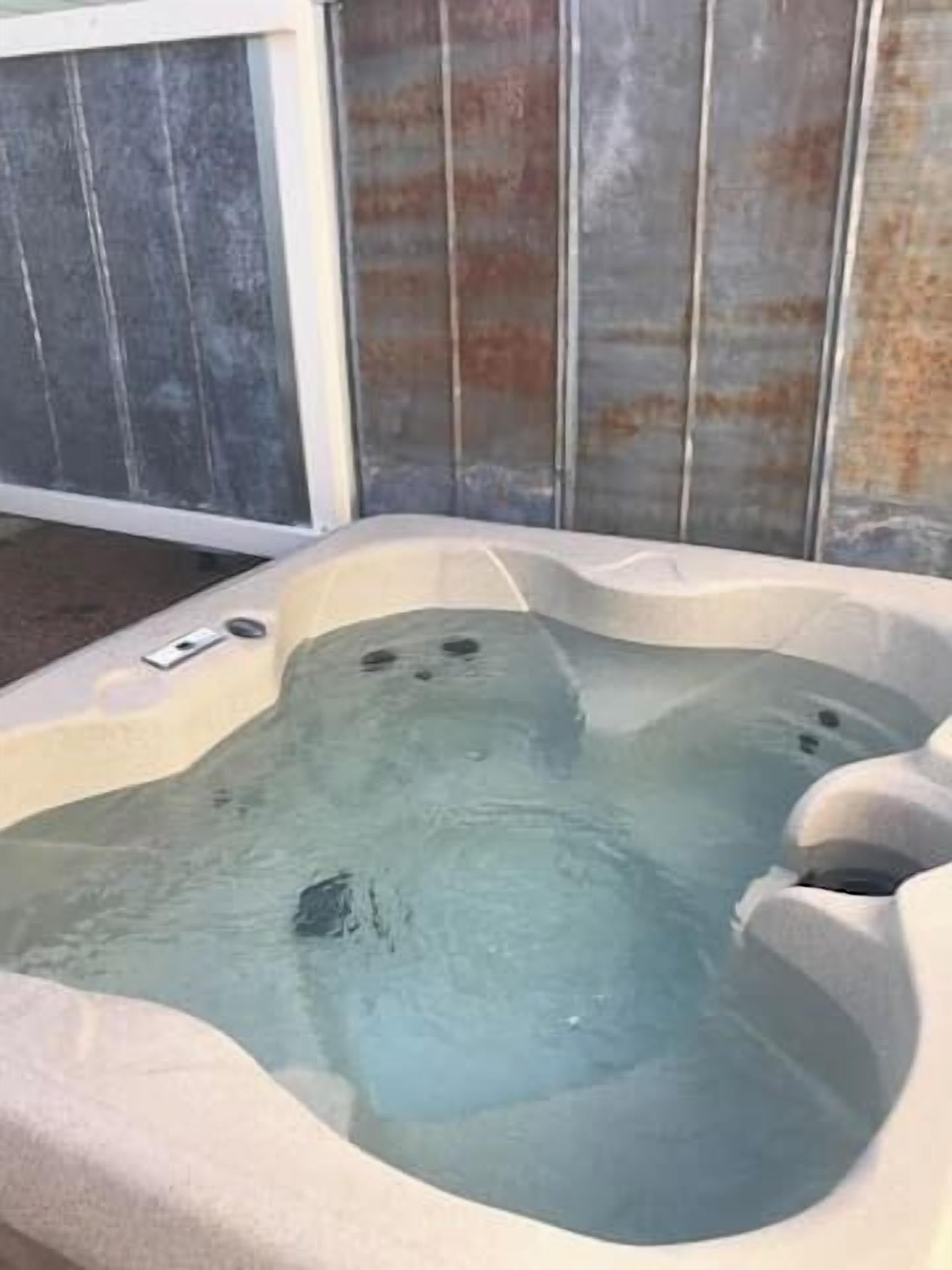 Un bain à remous de forme rectangulaire et à la surface texturée.