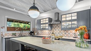 Een moderne keuken met een groot kookeiland, grijze kastjes en een backsplash met geometrische patronen.