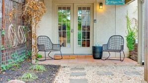 A covered patio with two chairs, a door with glass panels, and a sign reading "The Wangen Haus".