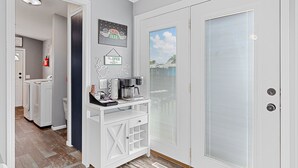 A clean, modern kitchen with a coffee maker, a sink, and a laundry area with washing machines. - Located near Mt. Rushmore, the Black Hills, Badlands National Park & more!! (Hermosa)