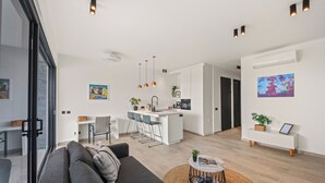 Un appartamento moderno con zona giorno, cucina e sala da pranzo.
