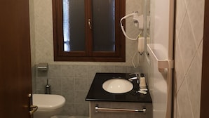 A bathroom with a toilet, a sink, and a mirror. - La Via Antiga - Apartment # 1 (Torre di Mosto)