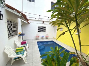 A small outdoor pool area with white chairs and a yellow wall. - Groundfloor 2BR with Private Pool: Palmas 3B (Bucerías)