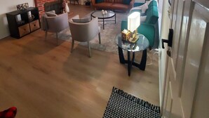Un salon avec une cheminée, un téléviseur, un ventilateur de plafond et un canapé.
