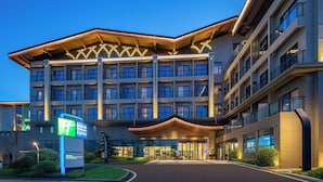Un hotel moderno con un ingresso ben visibile, diversi piani e una facciata luminosa.