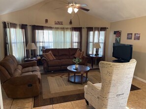 Relax in this stylish living room with a sofa, armchair, and coffee table, perfect for unwinding with a good view.