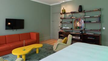 A modern living room with a red sofa, a yellow coffee table, and a bookshelf filled with books and decorative items.