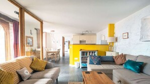 A modern living room with a sofa, coffee table, and a bookshelf. - St Davids Hideaway with Roll-top Bath & Log Burner (St Davids)