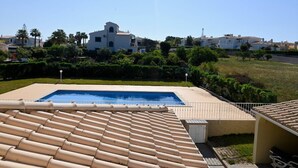 Una piscina en la azotea con vistas despejadas a edificios y zonas verdes circundantes.