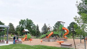 A playground with slides and climbing structures. - Modern Comforts: 3-Bedroom Townhome w/ 2 kid friendly community pools 
 (Fort Collins)