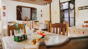 Zona de menjador amb una taula preparada per l'esmorzar, incloent pastissos i una tassa.