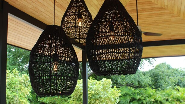 A wooden ceiling with hanging black woven light fixtures, a wooden sofa with cushions, and a foosball table. - Casa Zuri Luxury Villa + Guest House & Beach Club (Tamarindo)