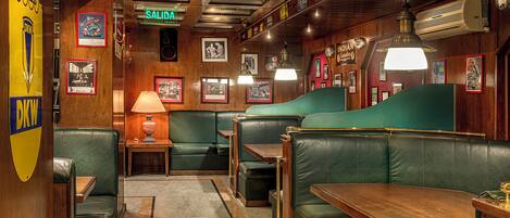 A restaurant interior with booths, tables, and a green counter.