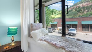 Una cama con vista a la calle y las montañas.