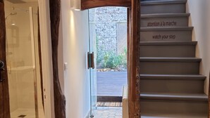 Un escalier doté d’une rampe en bois et d’un panneau affichant un message d’avertissement.