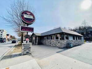 A restaurant with a stone facade, a signboard advertising homemade soups, and a clear sky.