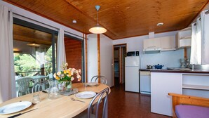 Cocina compacta con zona de comedor, techo de madera y vistas al exterior.