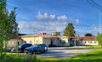 Um hotel com uma torre central, vários edifícios e carros estacionados.