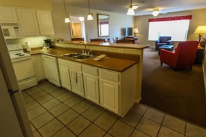 Cozy living area with a kitchenette, armchair, and TV.