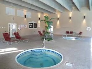 Relax by the oval-shaped pool surrounded by lounge chairs and lush greenery.