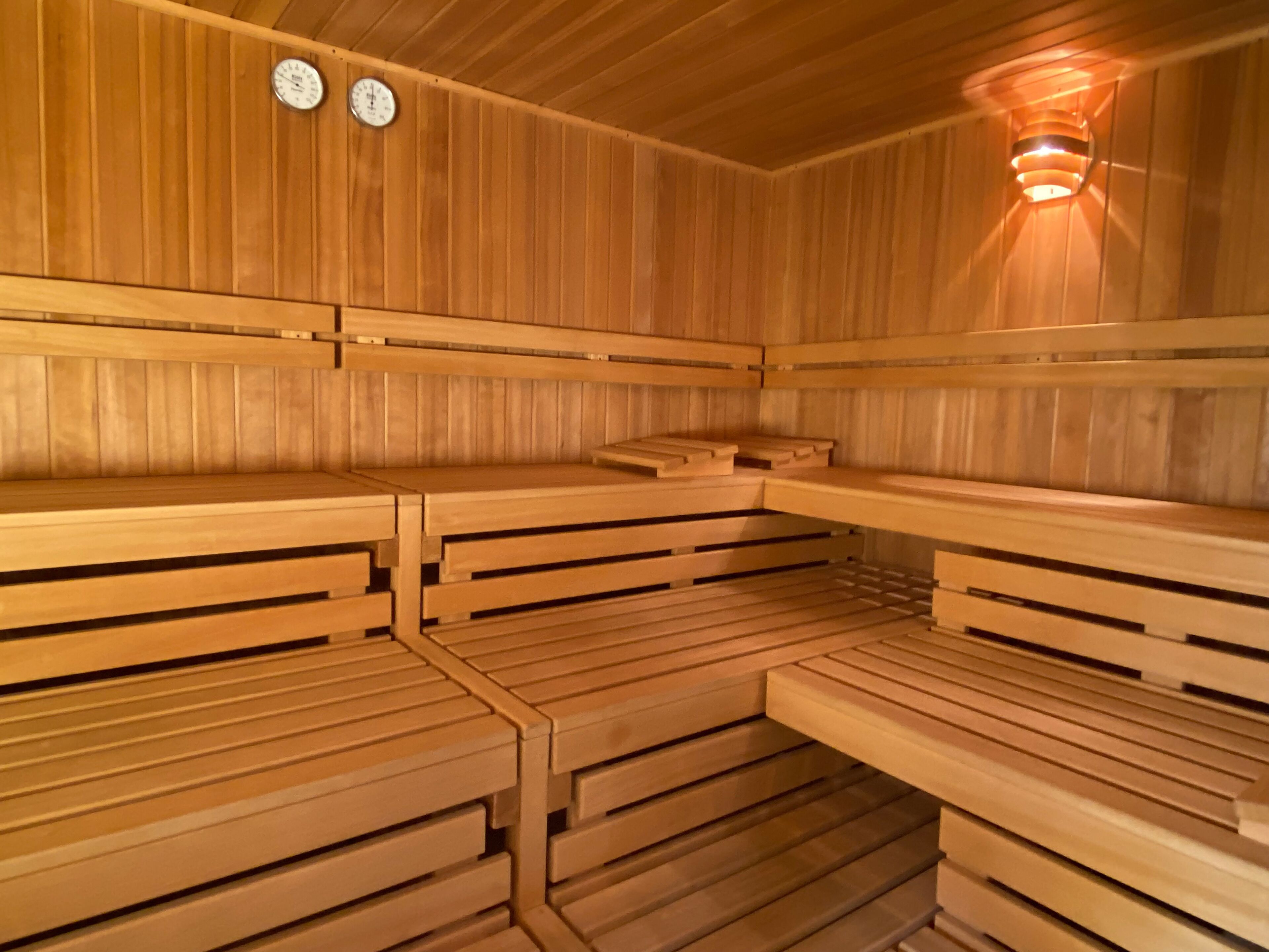 Un sauna avec des bancs en bois et une horloge fixée au mur.